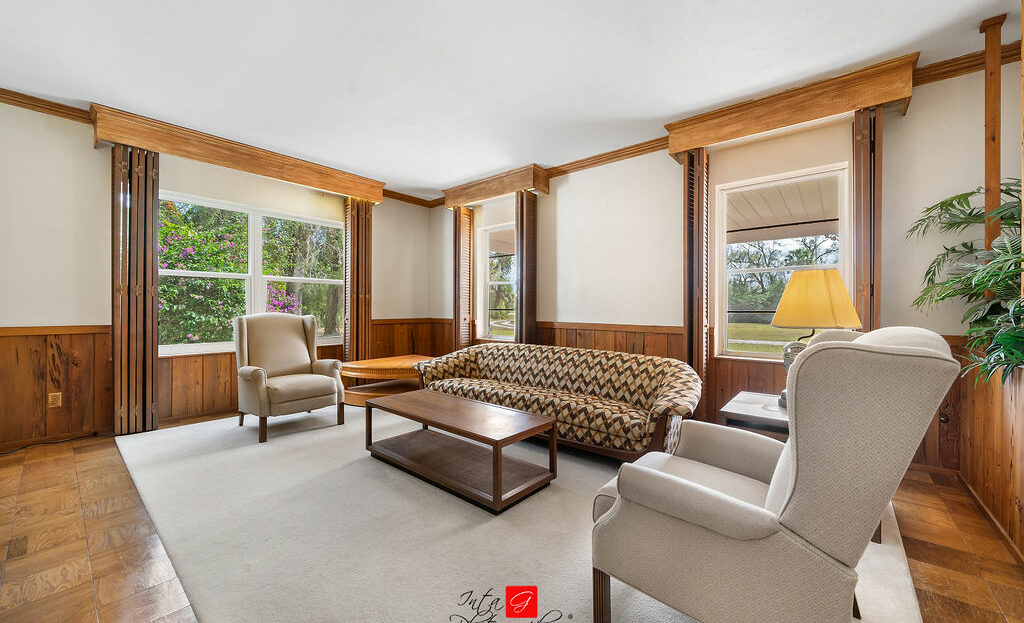A living room with wood paneling and a couch.