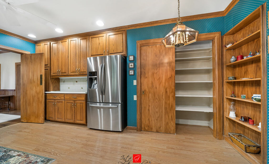 A kitchen with blue cabinets and a stainless steel refrigerator.