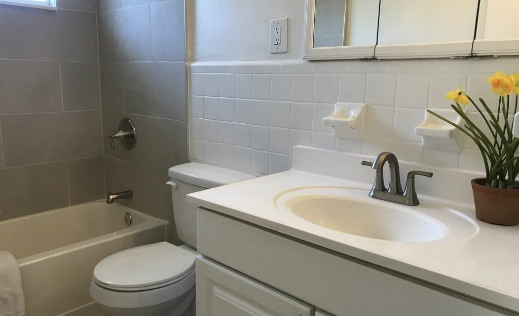 A bathroom with a sink, toilet and tub.