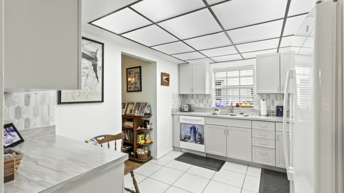 A white kitchen with a refrigerator and dishwasher.