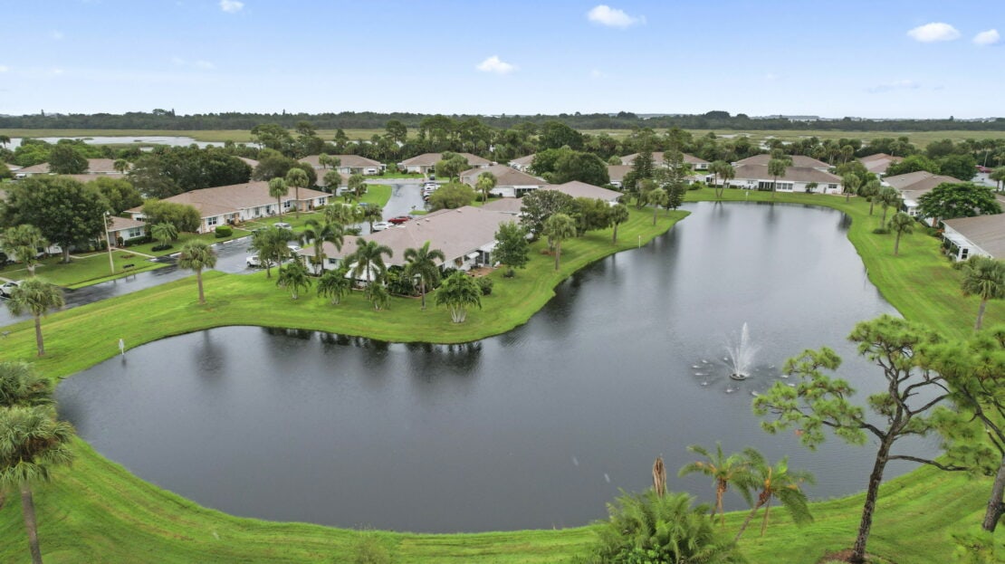An aerial view of a pond in a residential area.